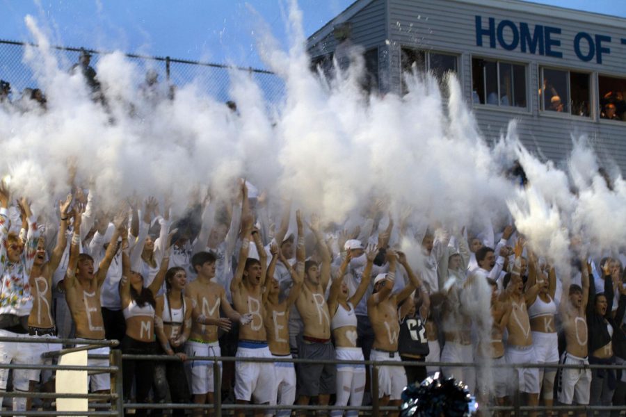 The student section throws baby powder up into the air during their white out game.