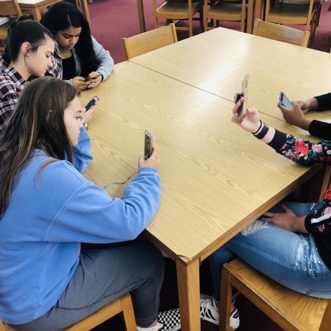 Students sitting on their phones instead of socializing. 
