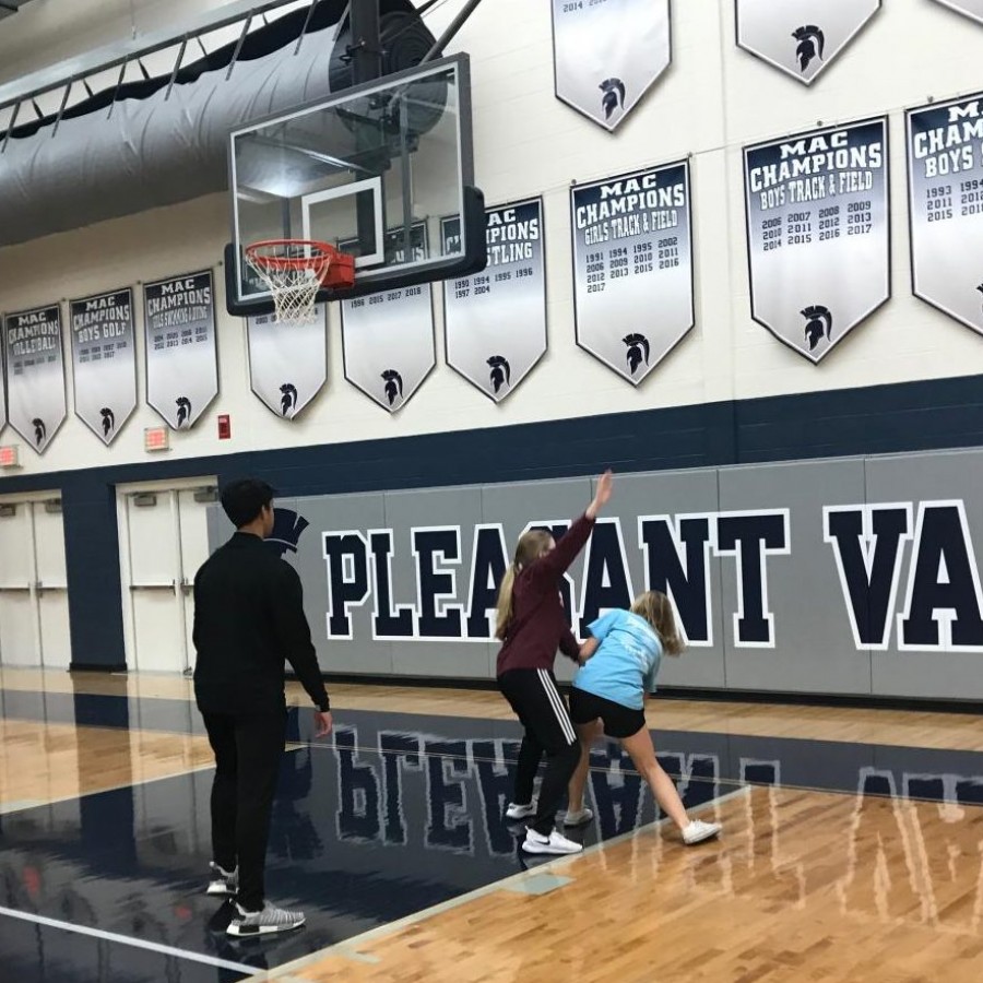 Students play a game of basketball
