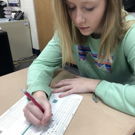 Student is filling out her answers for the Iowa Assessments. 