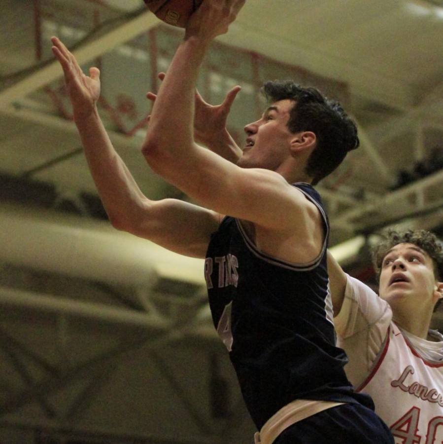 Junior, Jacob Parker, goes up for a shot against North Scott players. 