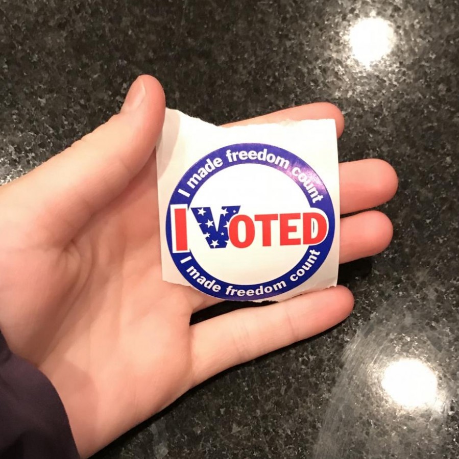 Young voter, Christy Bishop, displays her sticker proudly