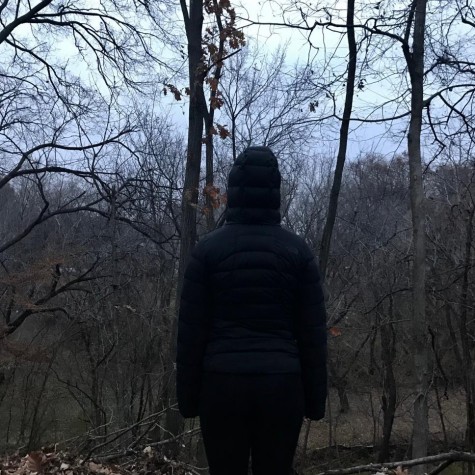 A student stands in front of a dark winter landscape