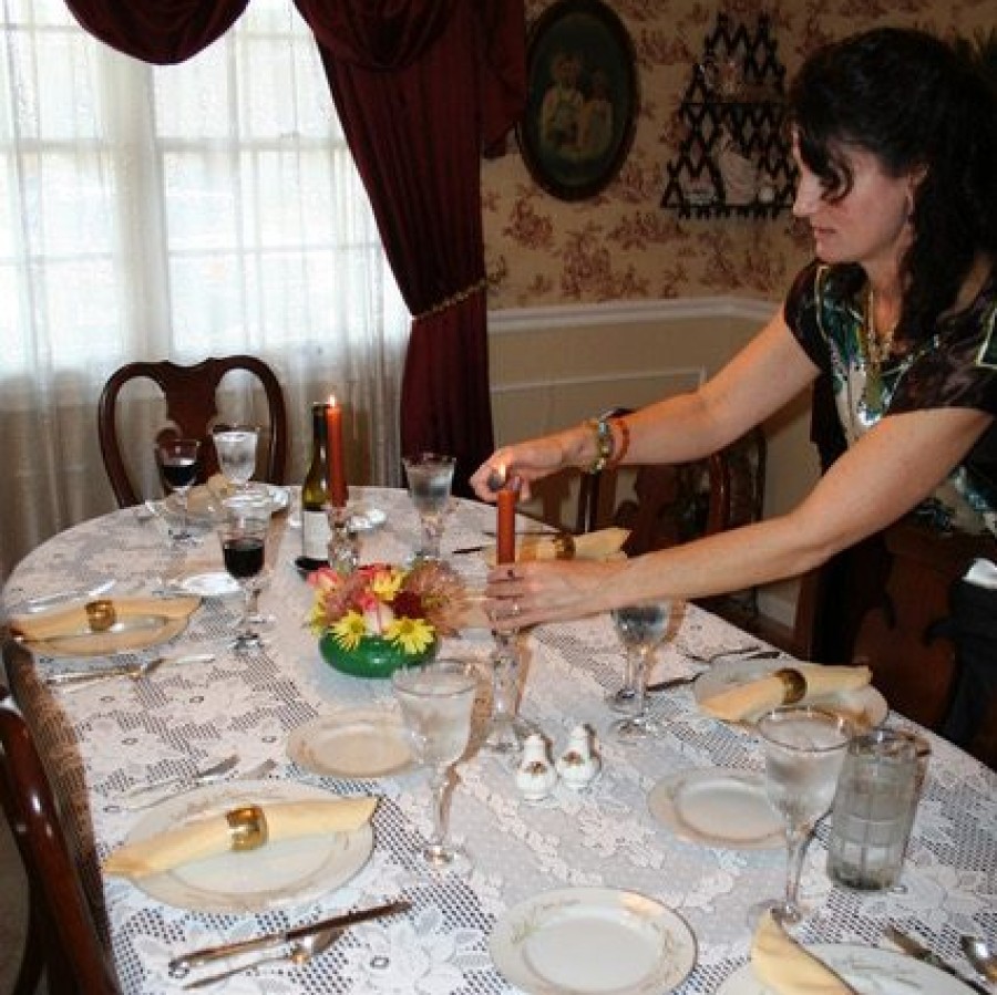 Woman+getting+the+dinner+table+set+up+for+a+large+family+Thanksgiving+meal