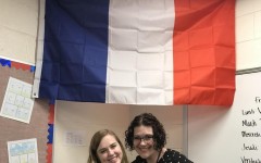 French Club teachers Melissa Lechtenberg and Marina Boes pose in front of Fances signature flag