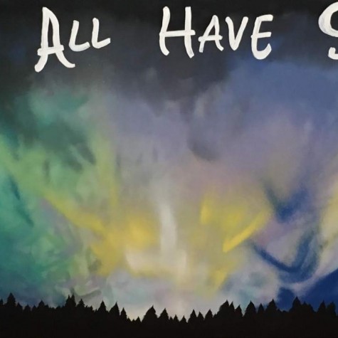 A mural painted of a night sky saying, We All Have Stuff