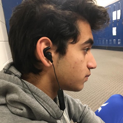 Junior wears earbuds in the hallway.