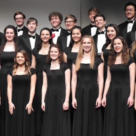 Some members of the 2018-19 PV Chamber Choir, standing stationary as they sing at a concert.