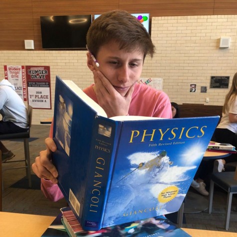 Senior, Jacob Bandy, reading books from three of his four AP classes he is taking currently.