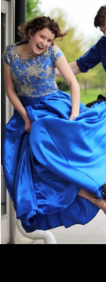 Stuent Emily Johnson jumps for joy in the prom dress she made