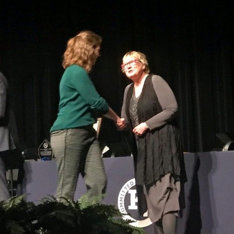 Kaitlyn Ryan shakes hands with Mike Zimmer and Michele Lynberg during the ceremony of Academic Awards night