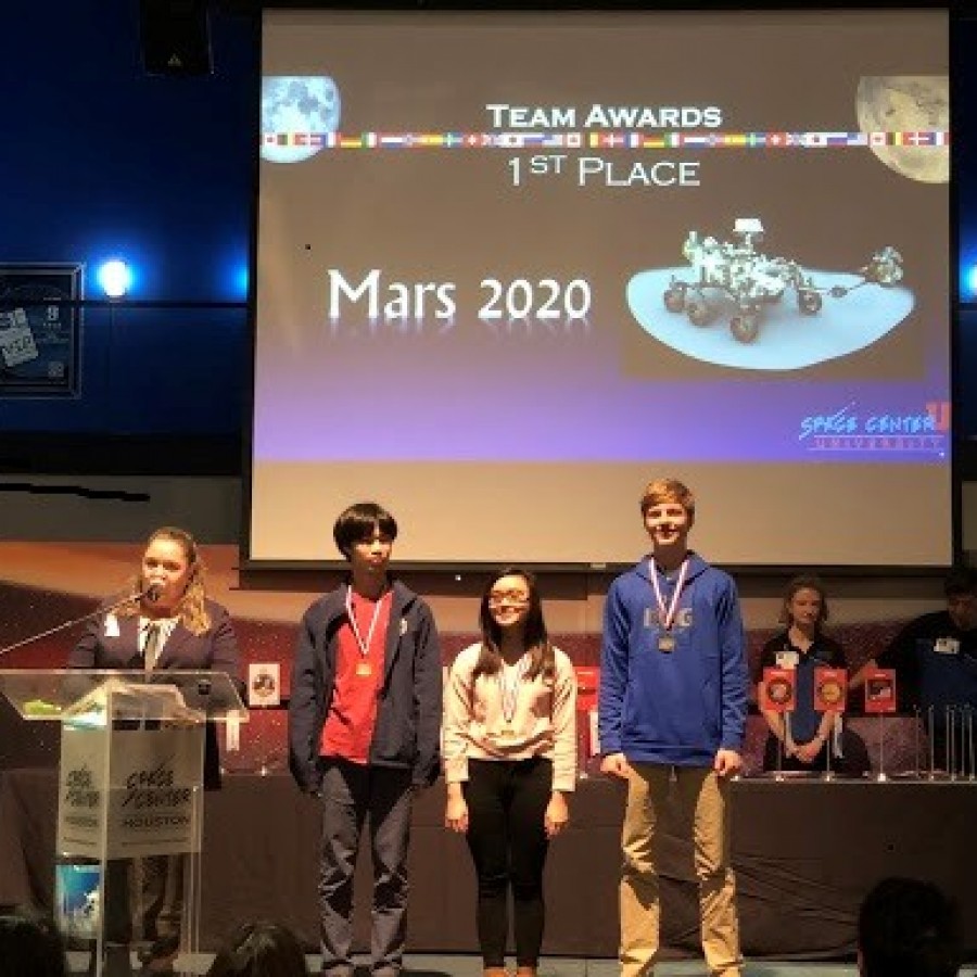 Gleb Hulting (right) accepts an award with his teammates Justin (left) and Ann (center) after winning the camp’s competition.