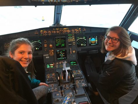 Sophie Malmen (left) and Trinity Malmen (right) sit in the cockpit of an airplane after their flight to Orlando, Florida.