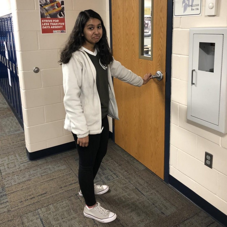 Senior Mahum Haque waits for a fellow student to let her into Mr. Fry’s locked English classroom before school.
