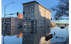 Cars lined up along the streets are barely to be seen, as they drowned in water, in downtown Davenports on the street of E 2nd St.  
