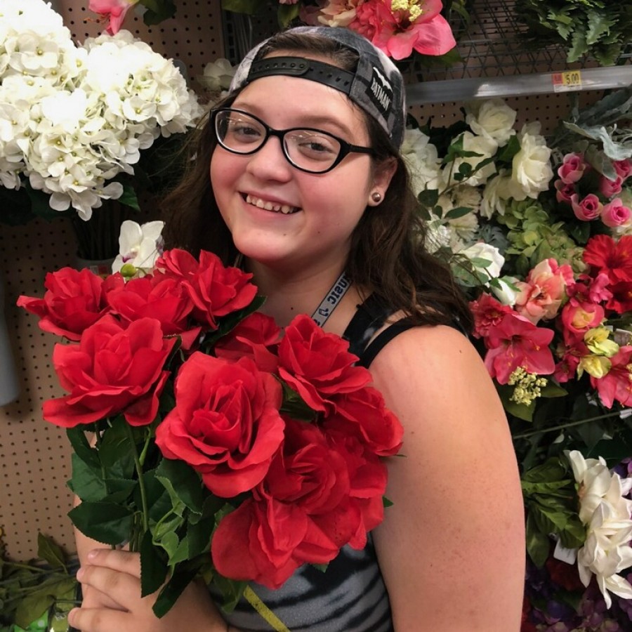 Kaitlyn Weeks poses for a photo with flowers while hanging out with her friends.