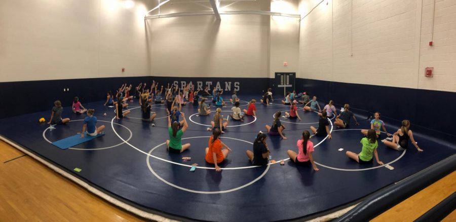 Girls cross country runners practice mindful breathing, guided by Julie Murphy.
