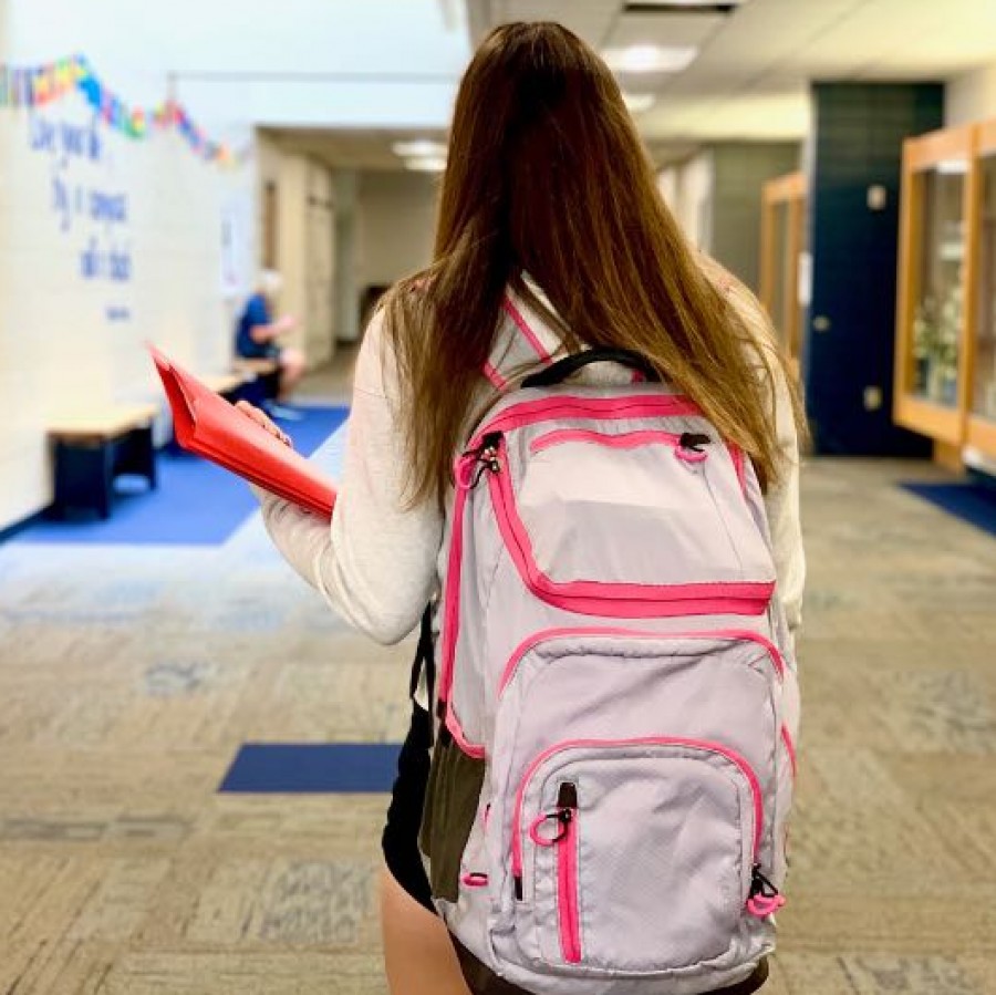 Student walking through school with their newly purchased school supplies