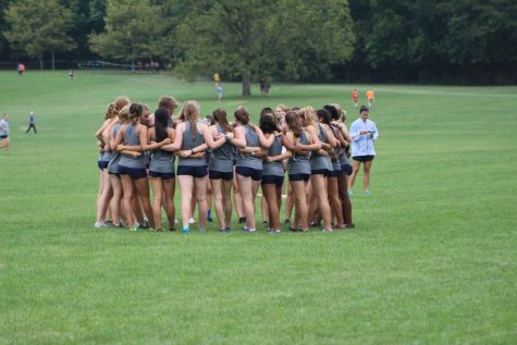 The JV girls cross country team huddles together to motivate each other before their race in Peoria on September 21st. 
