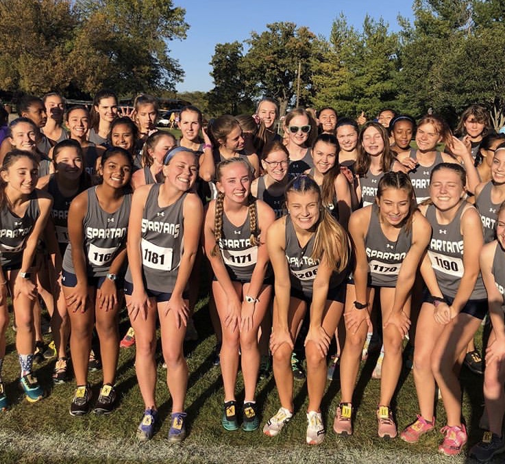The JV girls huddle up for a photo minutes before their race. 