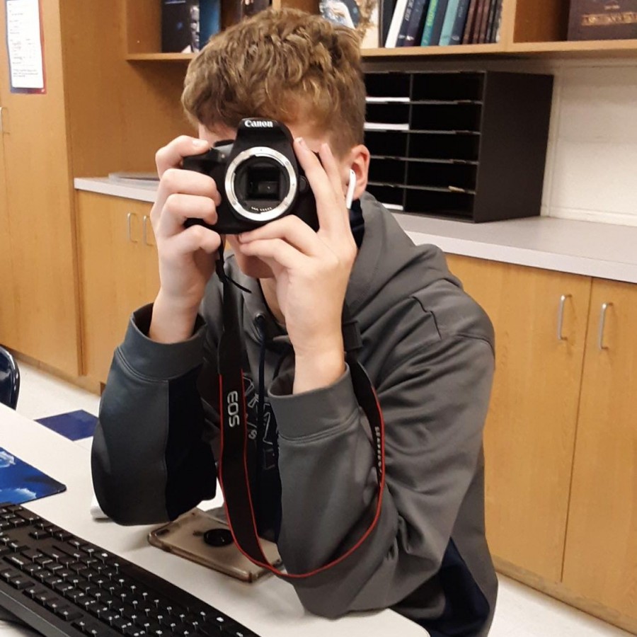 Senior Ian Wilger poses with a camera to show how body cameras can affect situations that police find themselves in. 