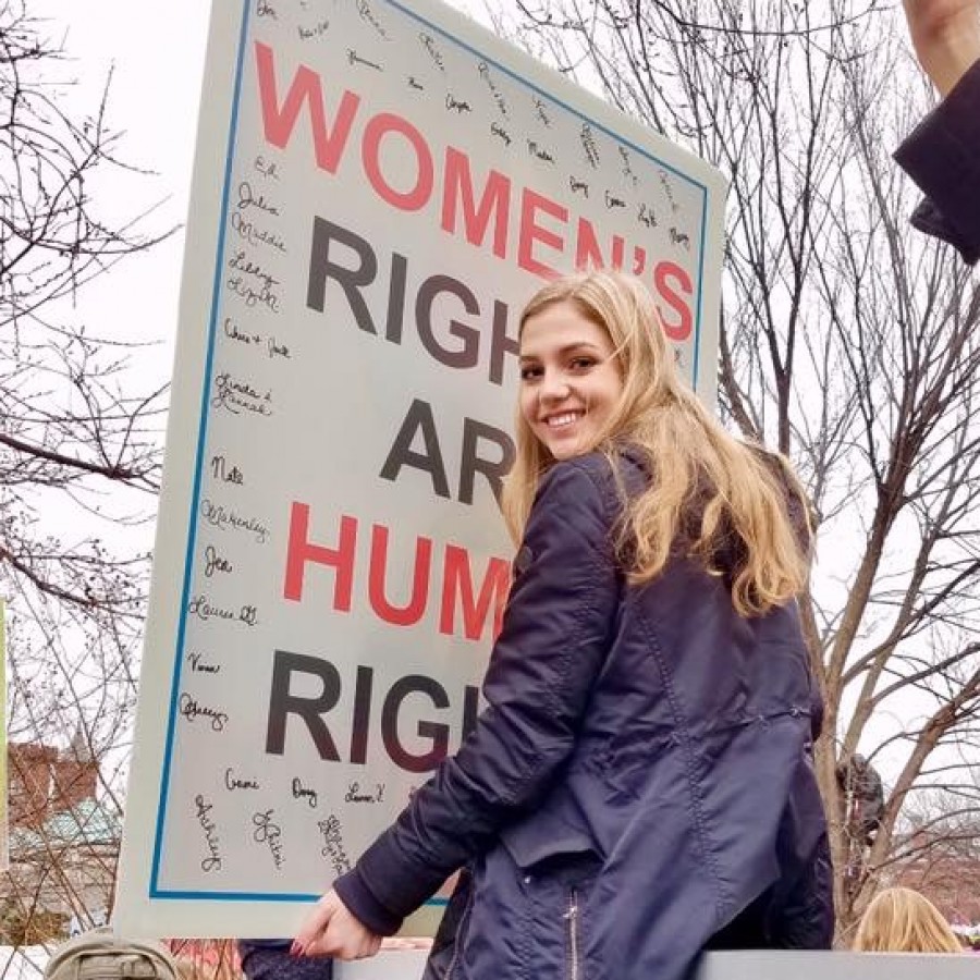 Alumni Lily Williams proudly displays her poster atop the Department of Justice sign, hoping to get a better view of the speakers at the Women’s March in Washington D.C. Williams is an avid supporter of women’s rights, including the right to vote. 