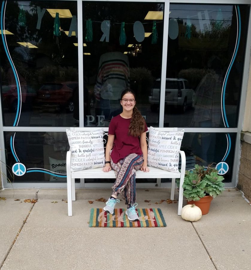 Senior Miranda Miller sits in front of Bettendorf's Peaceful Style Boutique.
