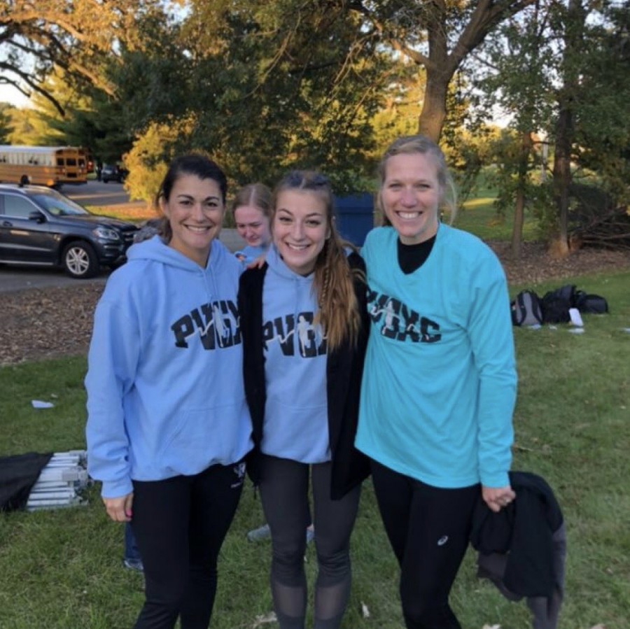 Senior Clare Basala stands amongst her female cross country coaches who have taught her about self-acceptance in the sport of running.