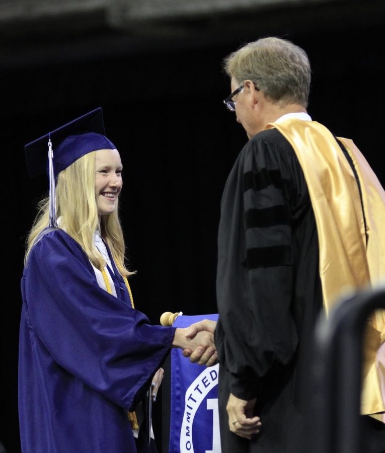 Former senior, Mallory Lafever receives a congratulatory handshake from Jim Spelhaug, former superintendent, after receiving her diploma at the graduation ceremony on May 27th, 2019. 