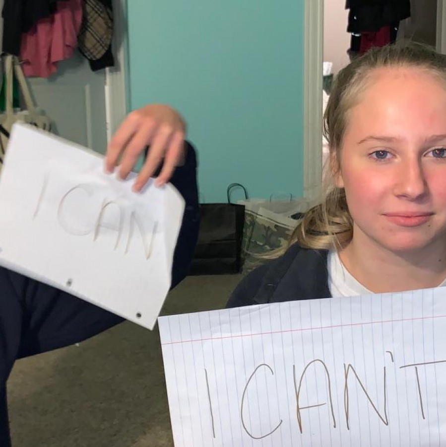 Chase Licea sitting next to Senior Abbey Wehrheim, Licea holding a sign saying I can while Wehrheims says I cant in representation of the recent sexism in the US government.