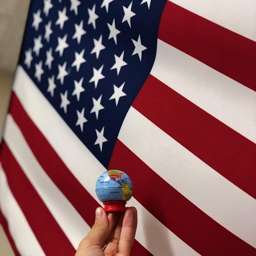 Senior Cienna Pangan holds a globe in front of the United States flag to represent the importance of focus on world news rather than just national news.