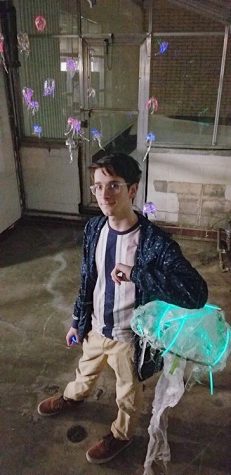 Baucom stands in front of his glowing jellyfish at a nighttime showcase. 