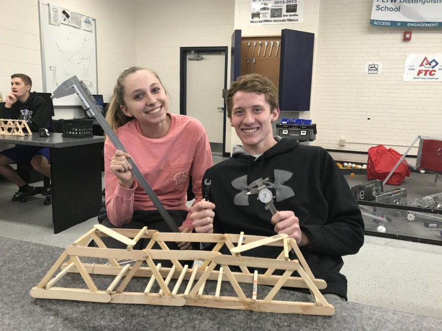 Seniors+Sara+Hoskins+and+Peyton+Weisbeck+pose+for+a+photo+with+their+submission+for+the+Bridge+Building+Contest+in+the+high+school+engineering+room.+The+contest+was+held+in+March+2019.