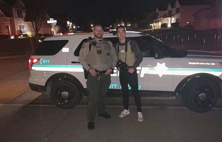 Senior Nate Martell with Deputy Fah outside of his Scott County police department car on Nov. 24.
