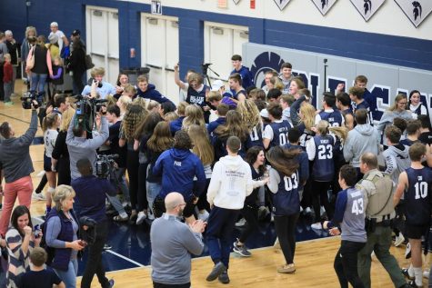 Spartan student section runs onto the court to celebrate with the 2019 Volleyball team after their regional final win against Bettendorf.