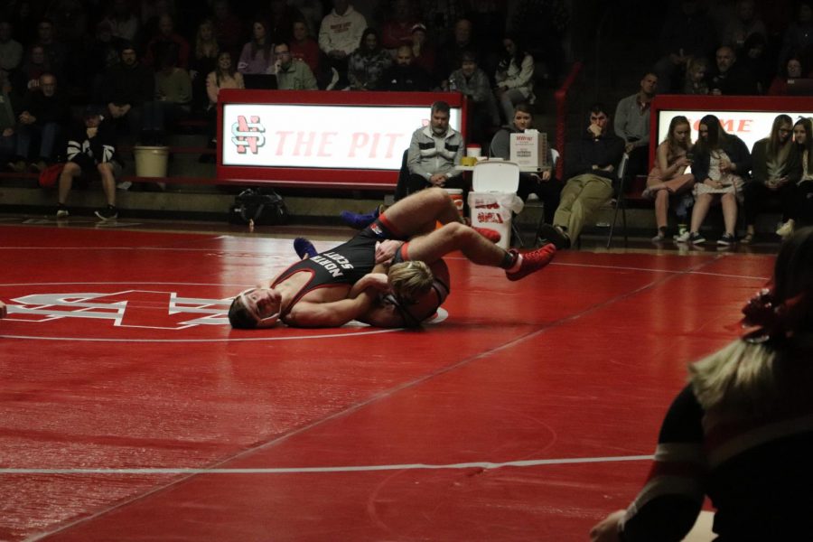 Senior Eli Lloyd attempts to pin opponent at North Scott wrestling meet. 
