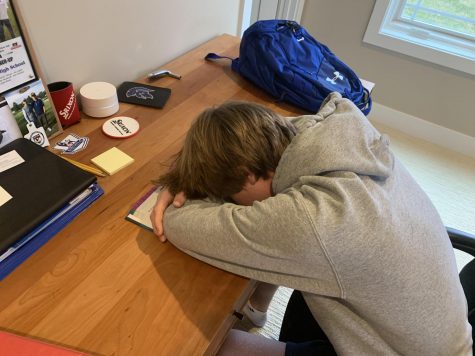Senior Lucas Wood falls asleep in a textbook while trying to do school work.
