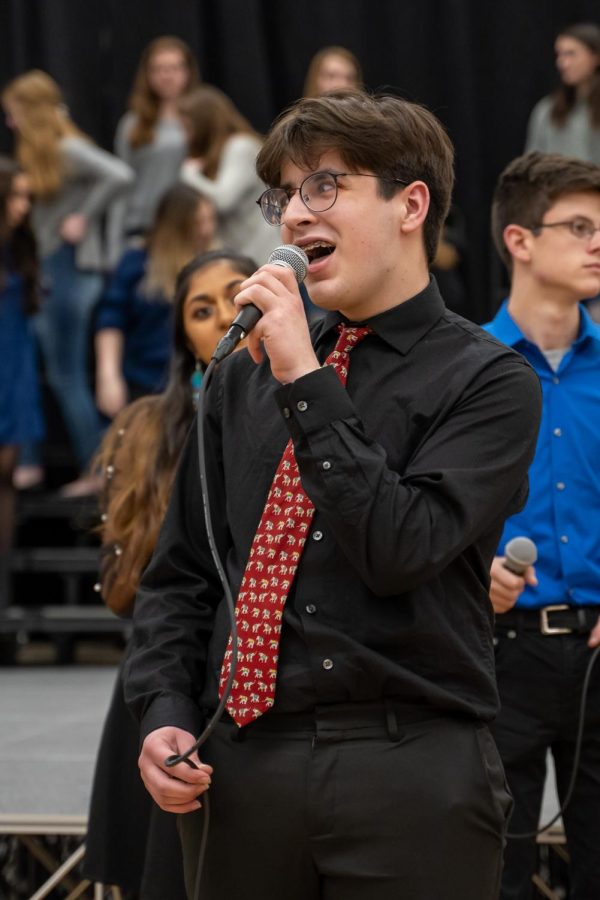 Freshman Tommy Glennon sings a duet in his jazz choir, Jazz Etc. at District Choral Fest held in the PVHS gym on Feb. 11.