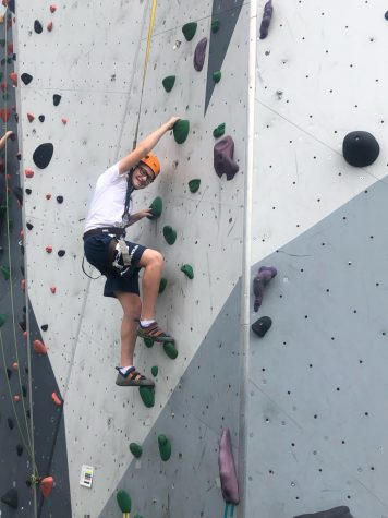 Seventh grader Avyn Nelson smiling while climbing a rock wall in Chicago, Illinois