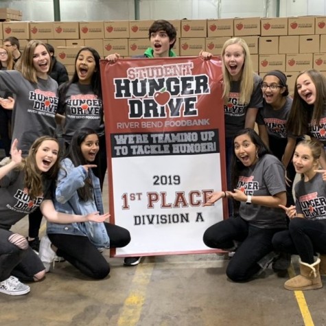  Members of Spartan Assembly hold the banner stating that Pleasant Valley won first place for the student hunger drive while at the Riverbend Food Bank. 