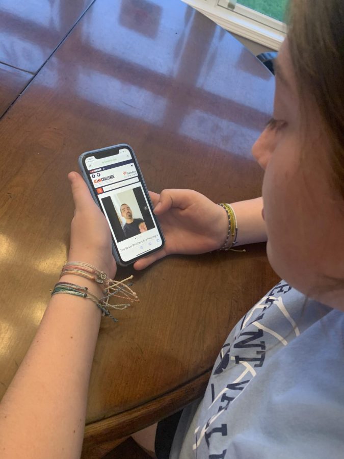 Freshman Molly Ramirez watches the Jonas Brothers’ ALL IN Challenge video on the ALL IN Challenge website about what they are offering for the winner of their sweepstakes.