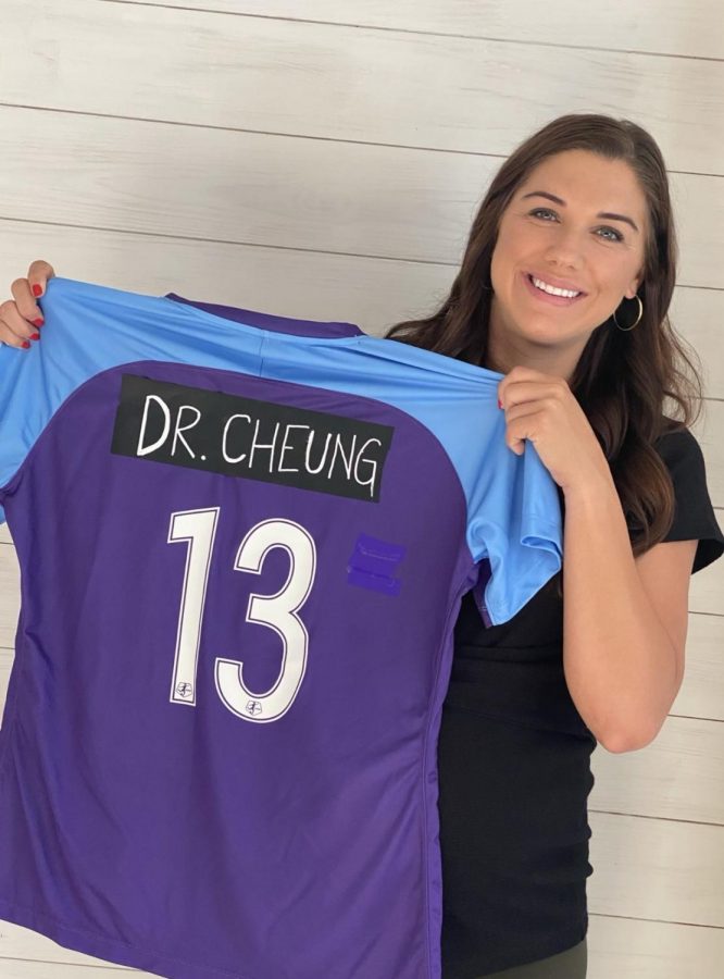 Professional soccer player, Alex Morgan, holds up one of her jerseys with Dr. Cheung’s name taped over hers.