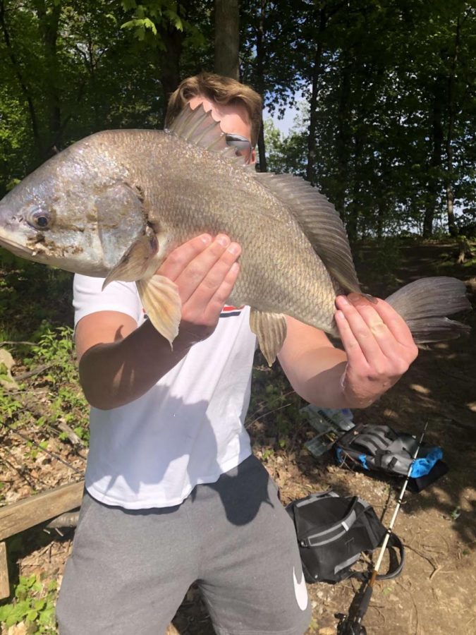 Junior Michael Vanderschaaf holding Drum fish he caught 
