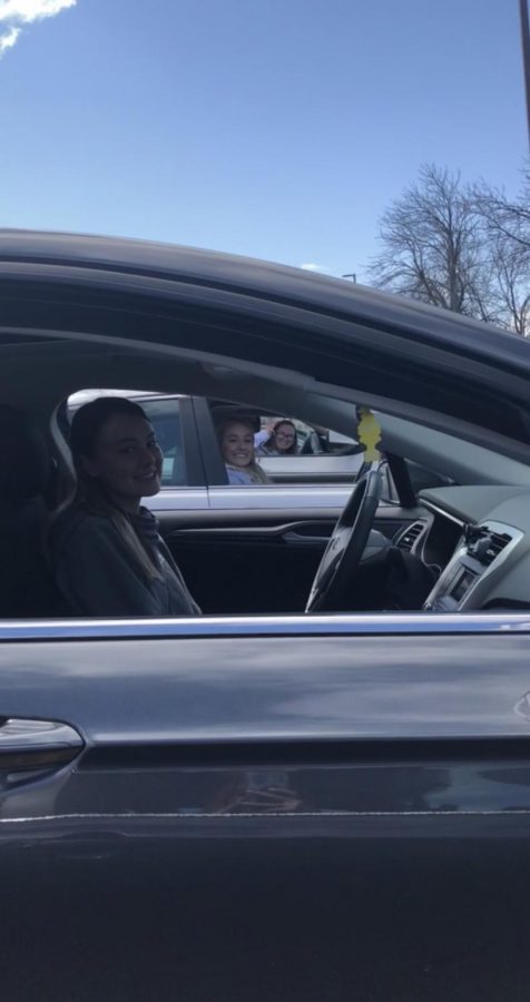 Seniors Emma Curtis, Hannah Anderson, and Lauren Steinhart social distance hang out from their cars during quarantine.
