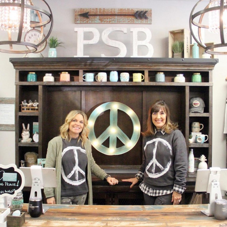 Local small business owners Linda Mowbray and Chris Slavens posing in their boutique, Peaceful Style.