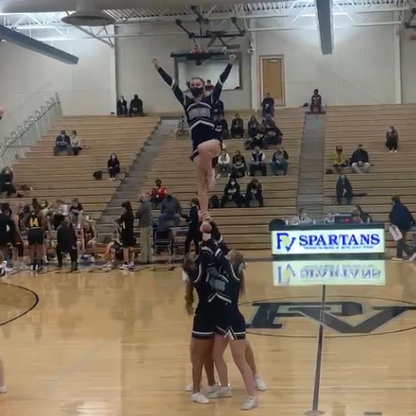 Savannah Ervin flys a lib- after many years of basing- for her stunt on senior night, just a few games before her last.