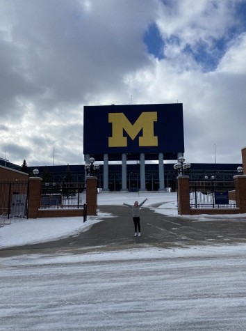 Sarah Babka stands in front of the University of Michigan, beaming with excitement, during her college visit.