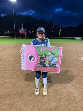 Jessi Meyer posing with the state participant banner after winning the substate final game during her junior season