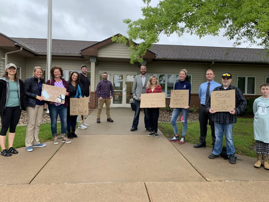 Community members gather outside the Belmont administrative building with signs urging the board to repeal its mask mandate before the May 18 board meeting.