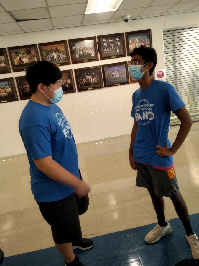 Junior Tejus Kanathur (right) interacts with junior Jun Oh (left) while wearing a mask.